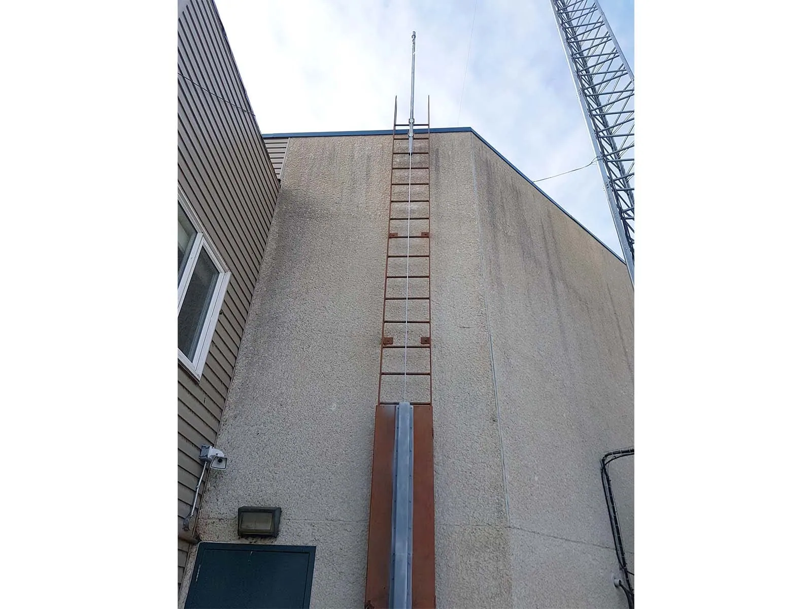 Fall protection system installed on exterior ladders for safe building access