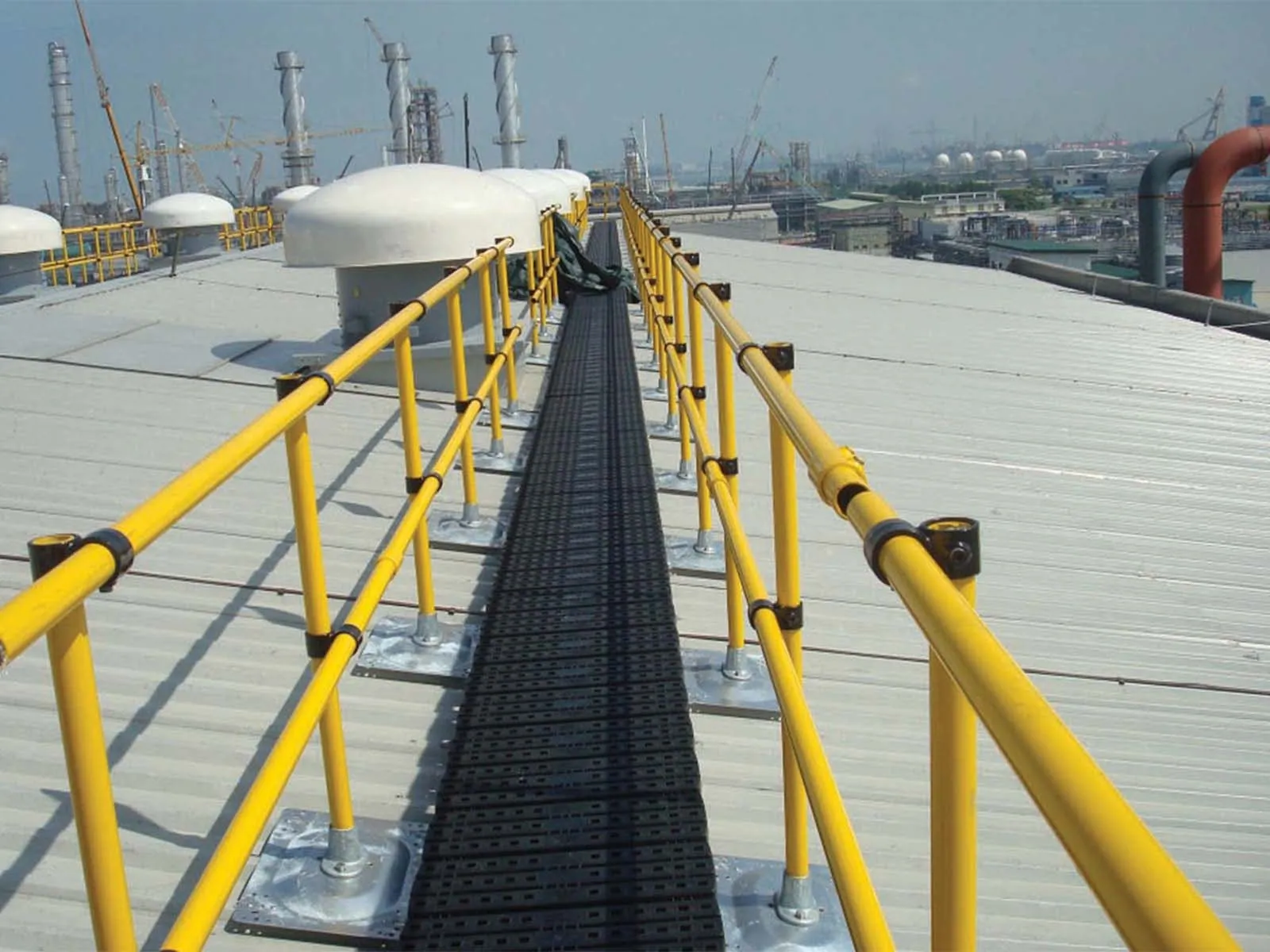 Elevated catwalk system with guardrails for safe access in industrial facility