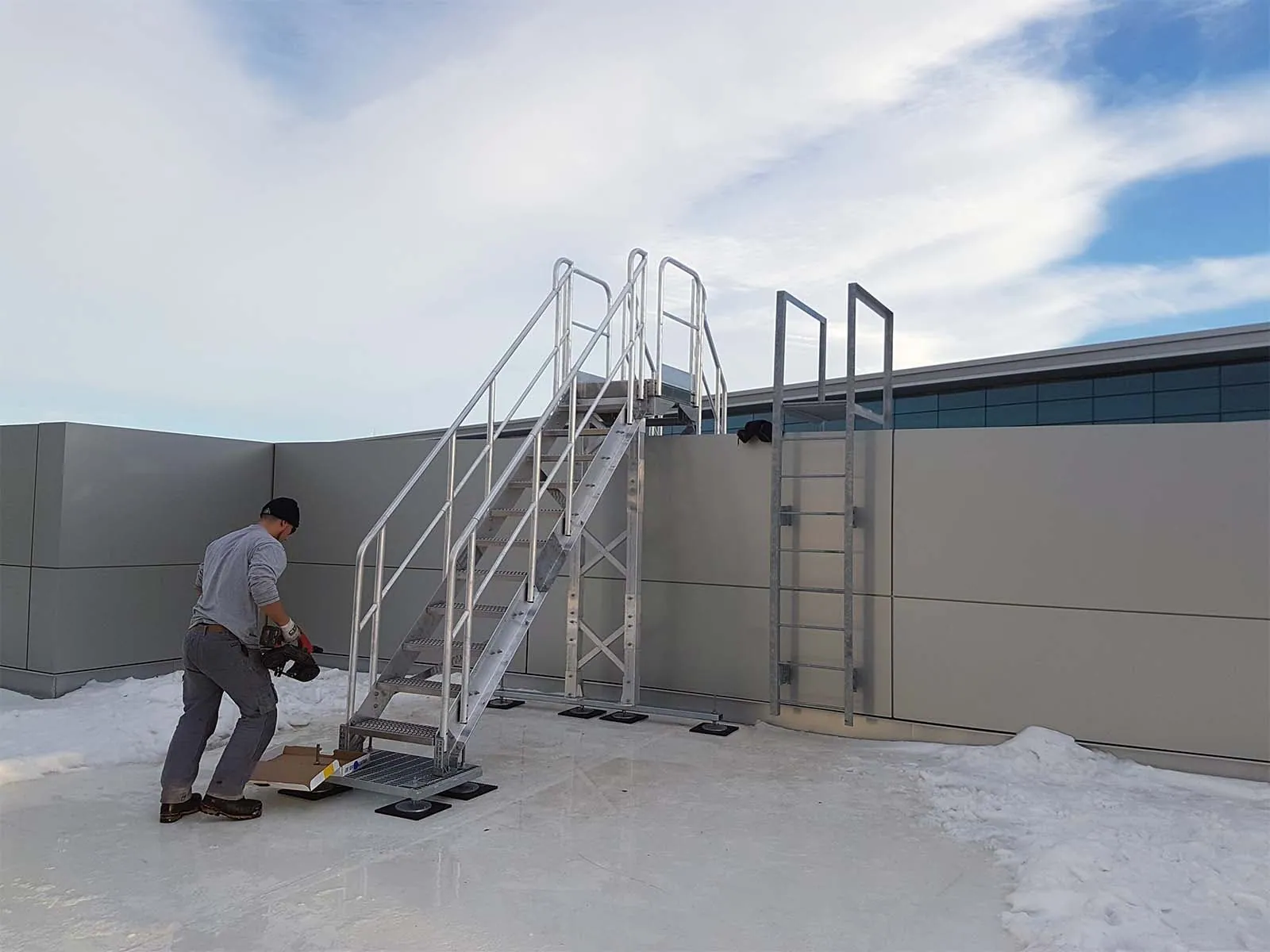 Technician using lifeline system while accessing rooftop equipment for maintenance