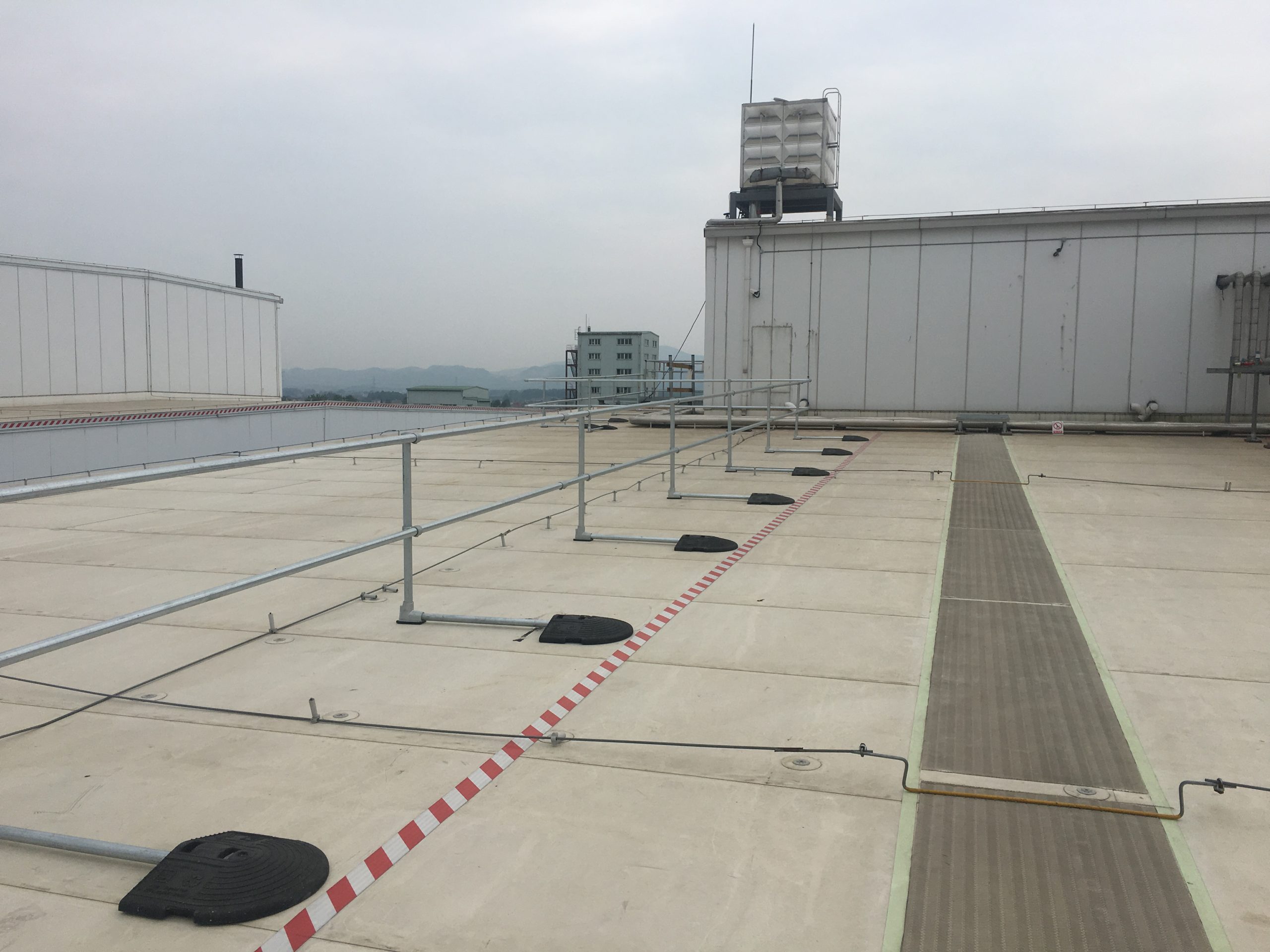 Non-penetrating guardrail system providing rooftop leading edge fall protection