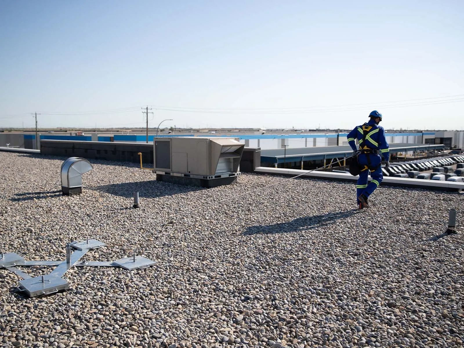 Non-penetrating roof anchor system installed on flat commercial rooftop for fall protection
