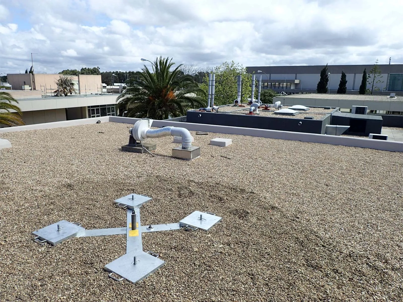 Non-penetrating roof anchor system installed on flat commercial rooftop for fall protection