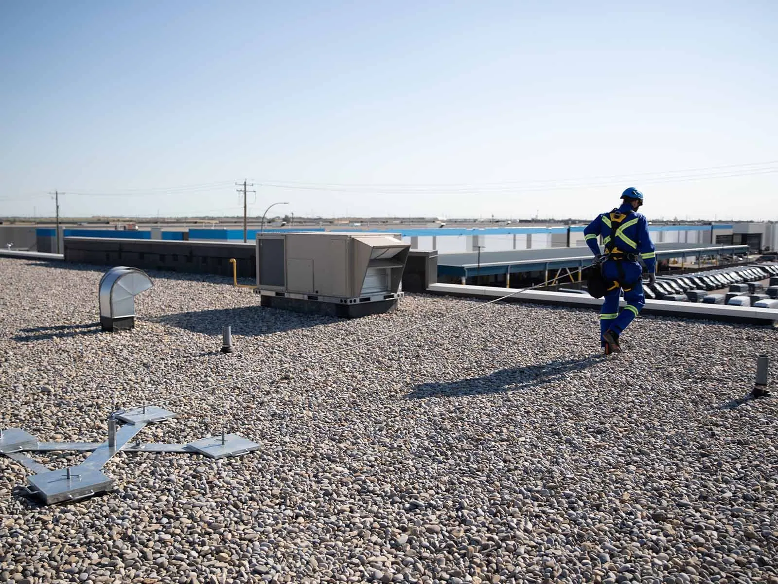 Non-penetrating roof anchor system installed on flat commercial rooftop for fall protection