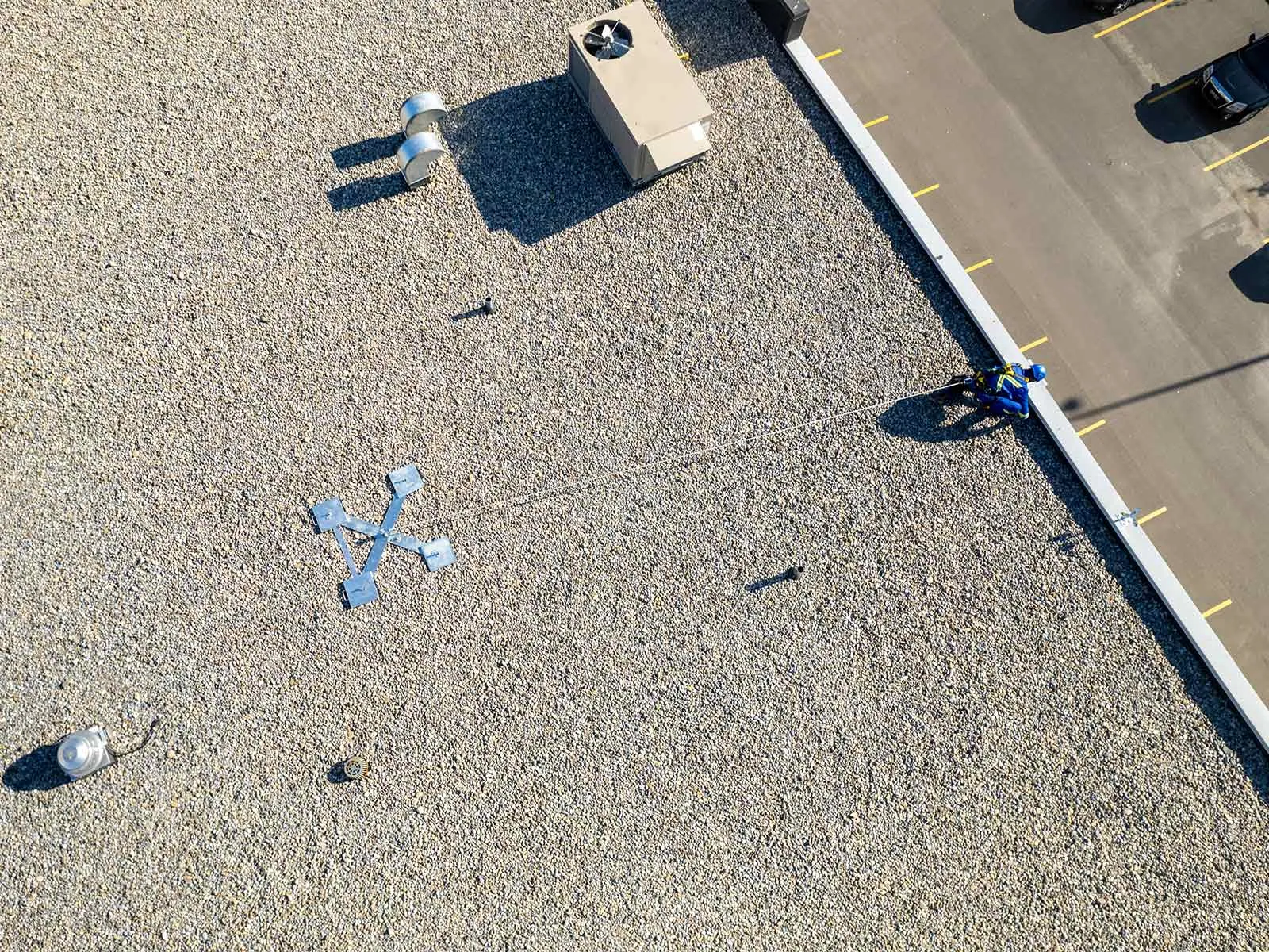 Non-penetrating roof anchor system installed on flat commercial rooftop for fall protection