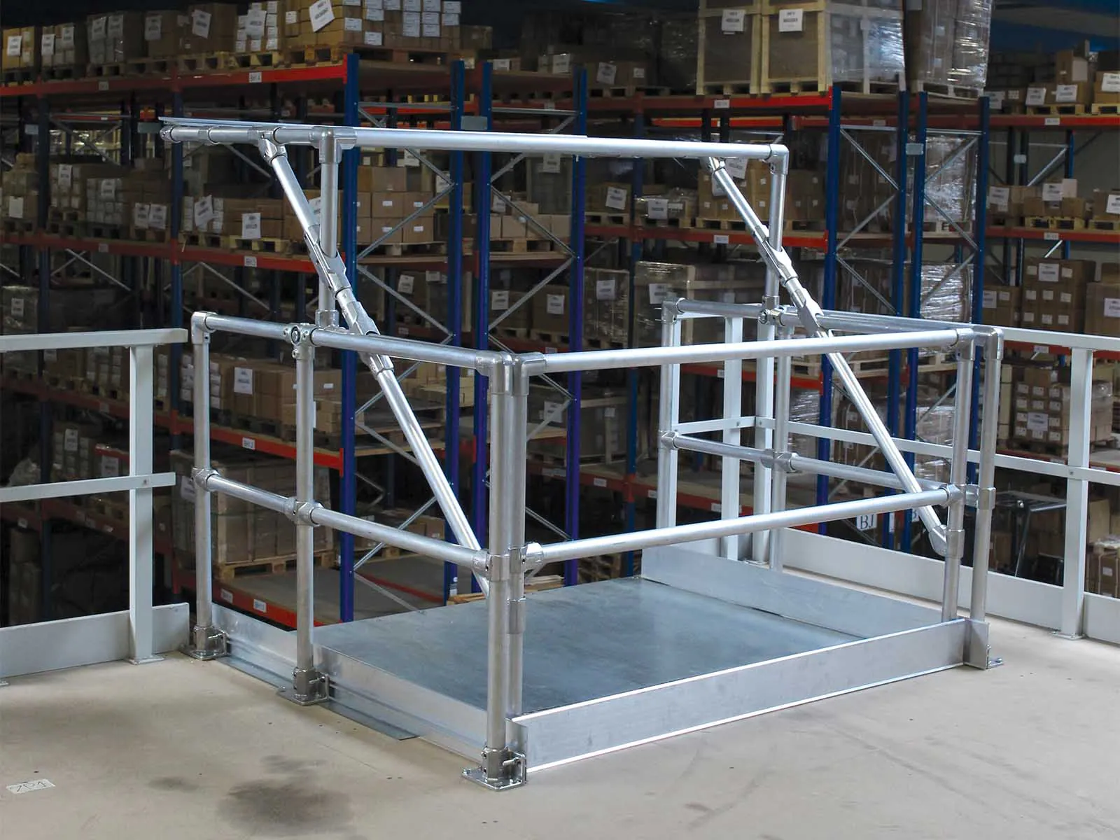Self-closing pallet gate installed on mezzanine platform for fall protection