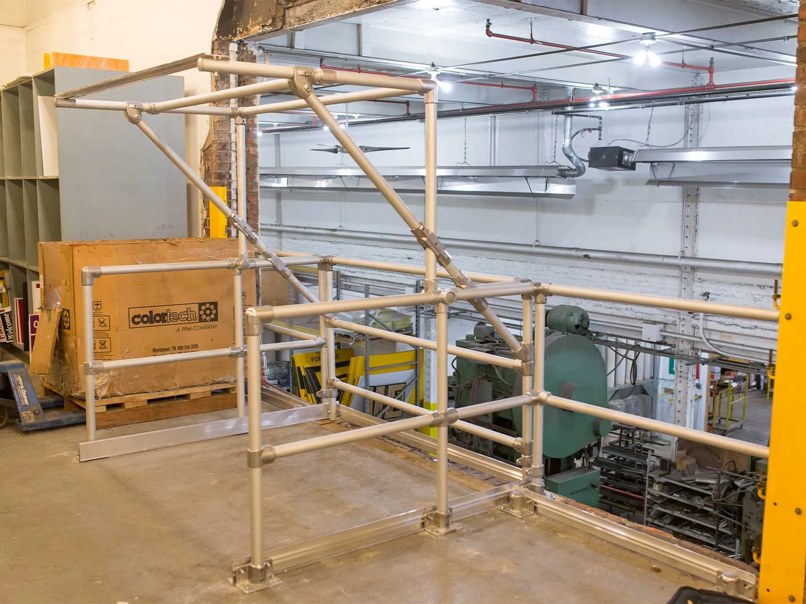 Self-closing pallet gate installed on mezzanine platform for fall protection