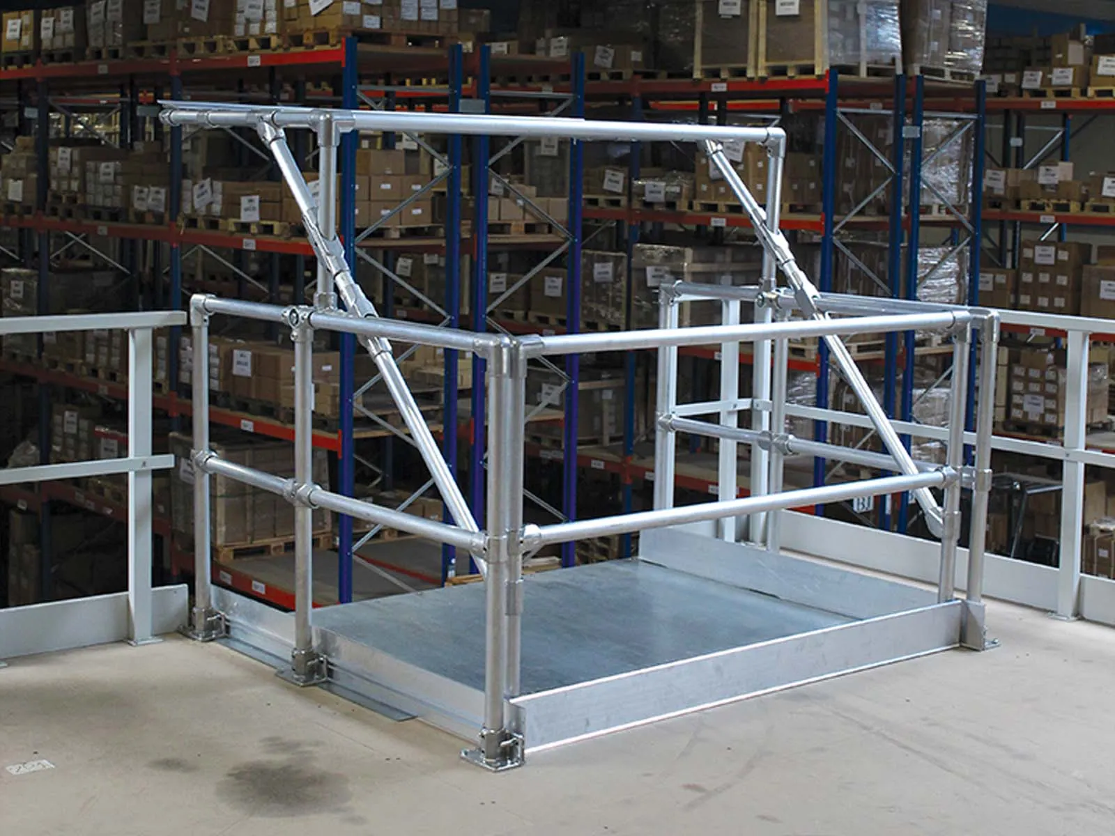 Self-closing pallet gate installed on mezzanine platform for fall protection
