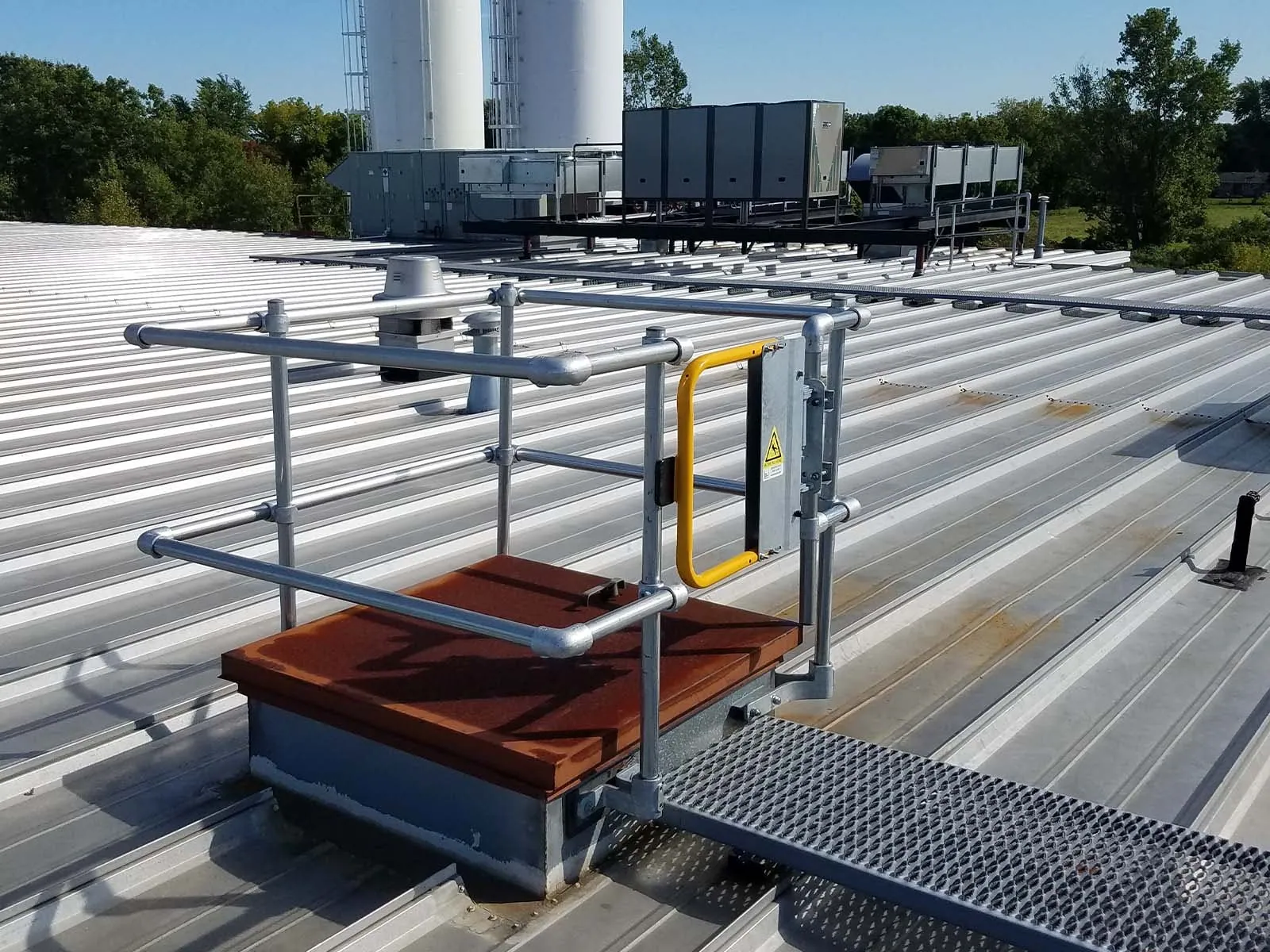 Guardrail system installed around roof hatch to prevent fall hazards