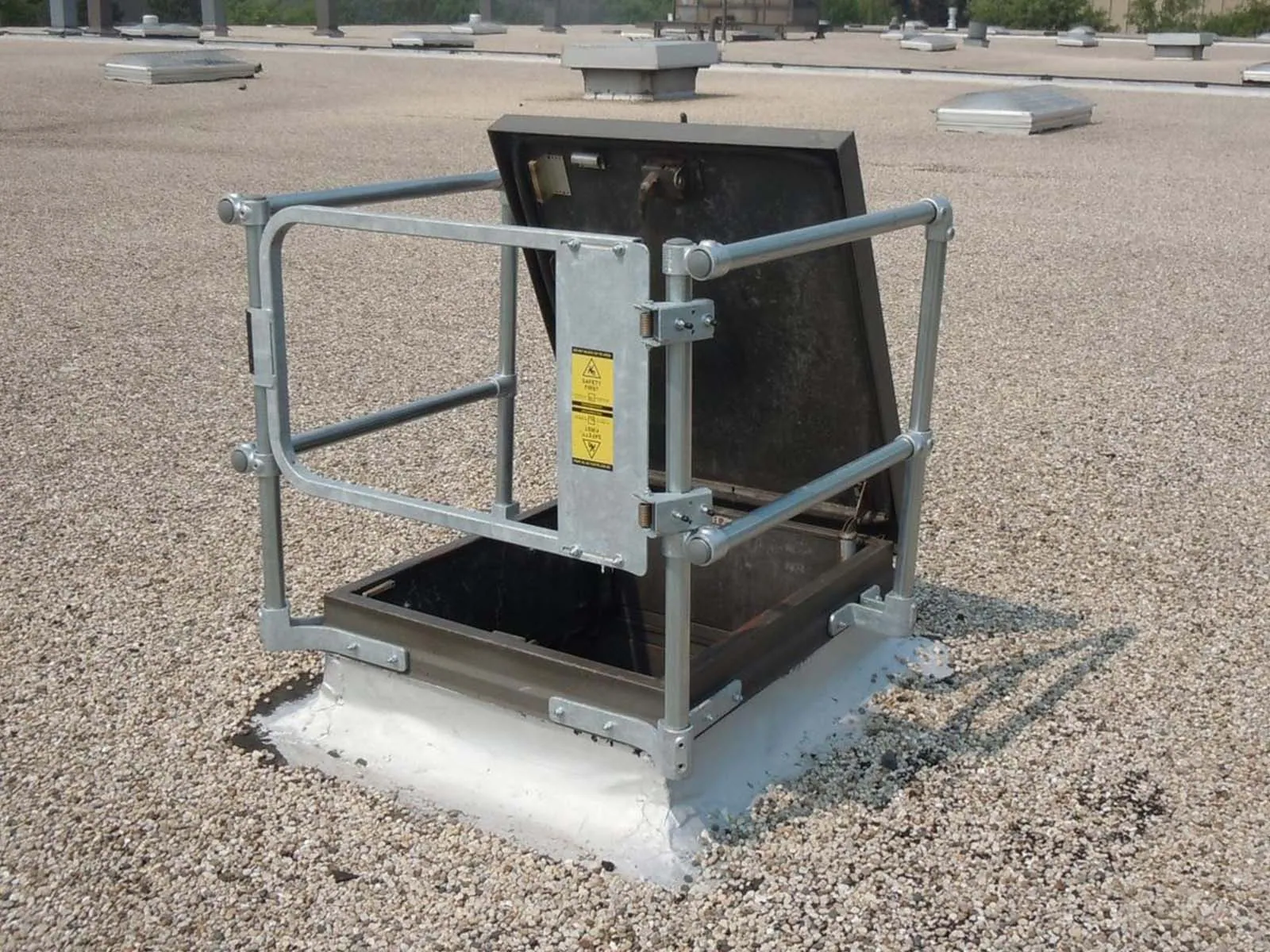 Guardrail system installed around roof hatch to prevent fall hazards