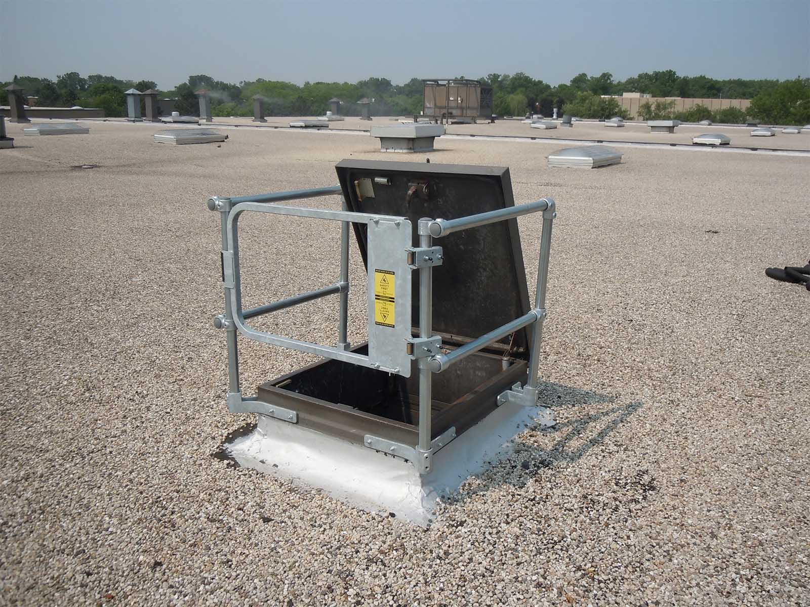 Guardrail system installed around roof hatch to prevent fall hazards