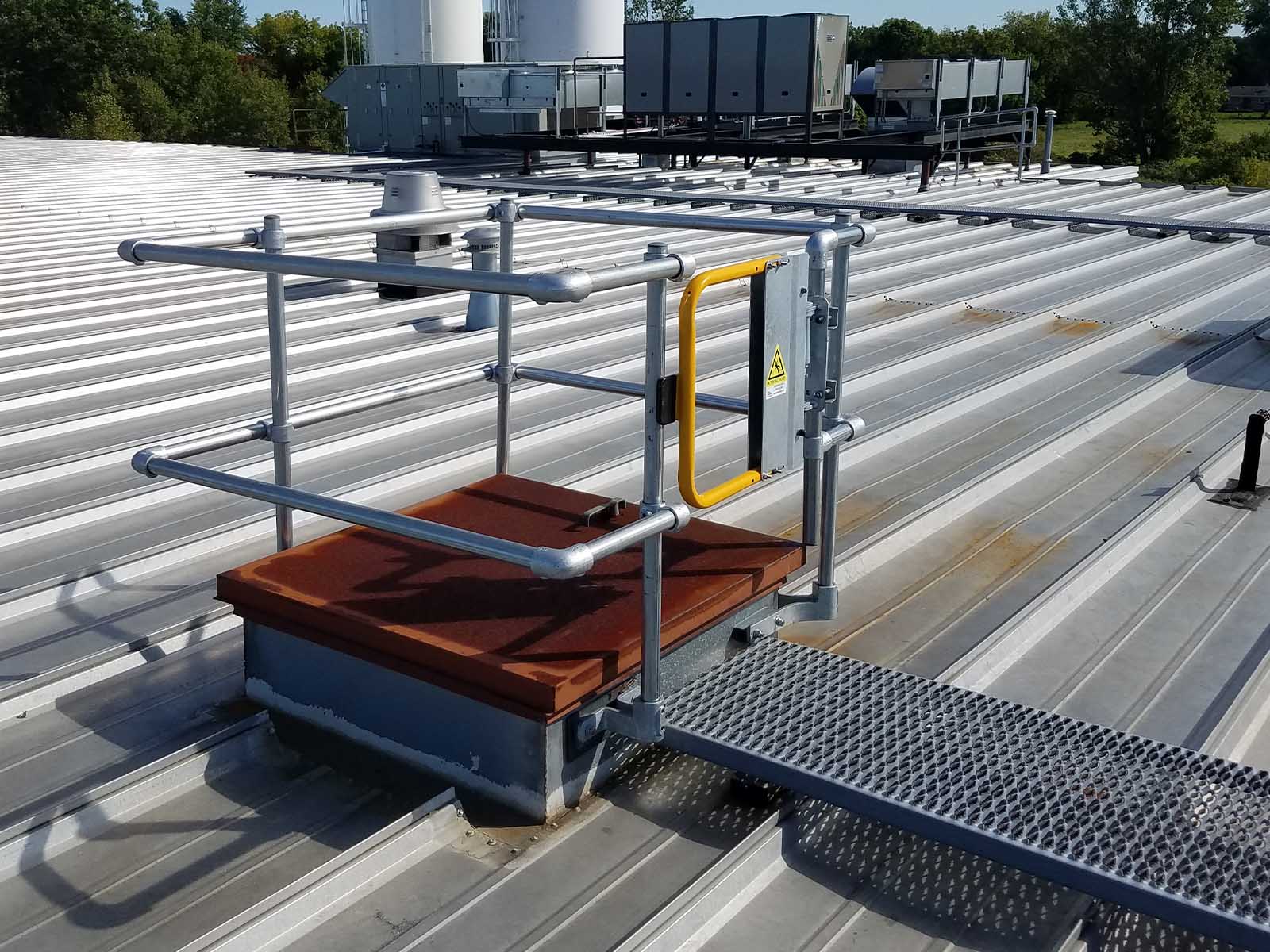 Guardrail system installed around roof hatch to prevent fall hazards