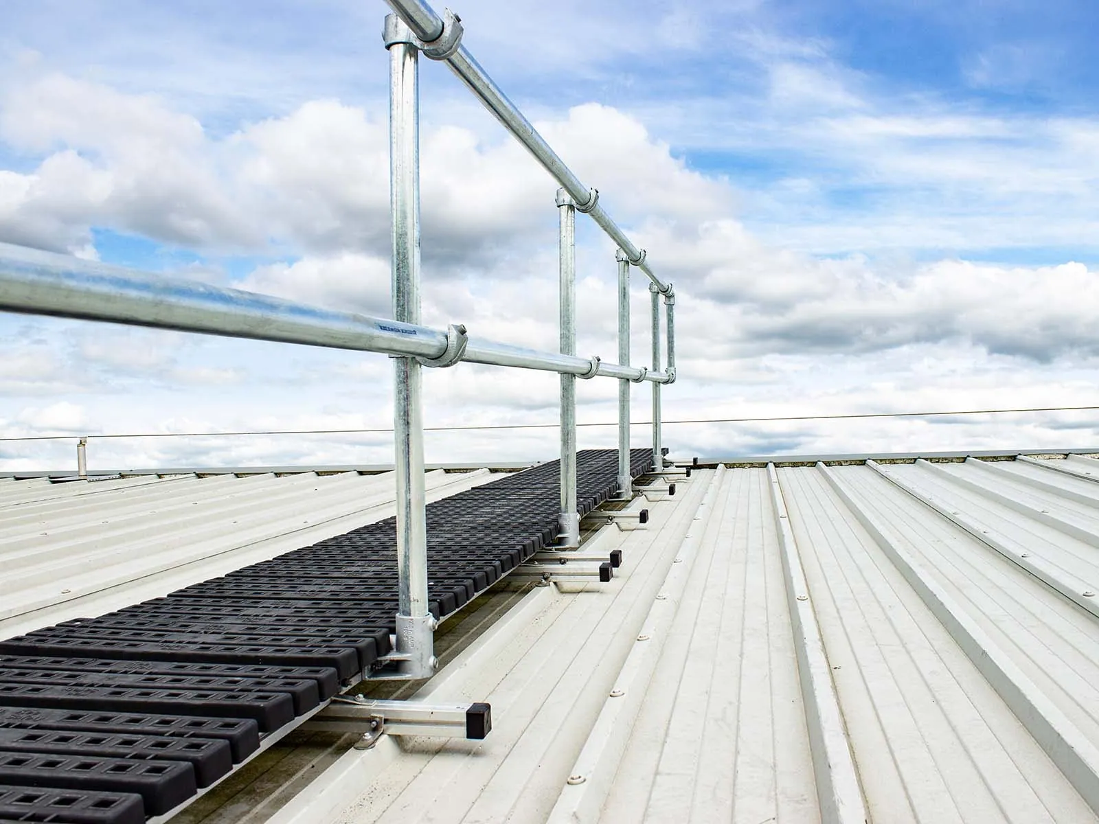 Rooftop walkway system with guardrails for safe pedestrian access on flat roofs