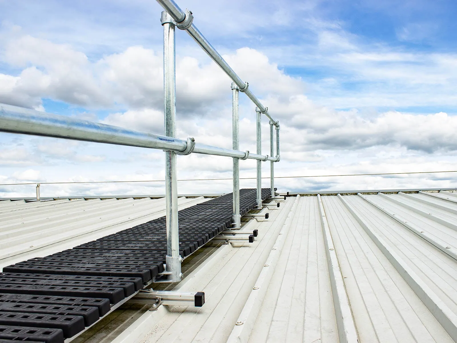 Rooftop walkway system with guardrails for safe pedestrian access on flat roofs