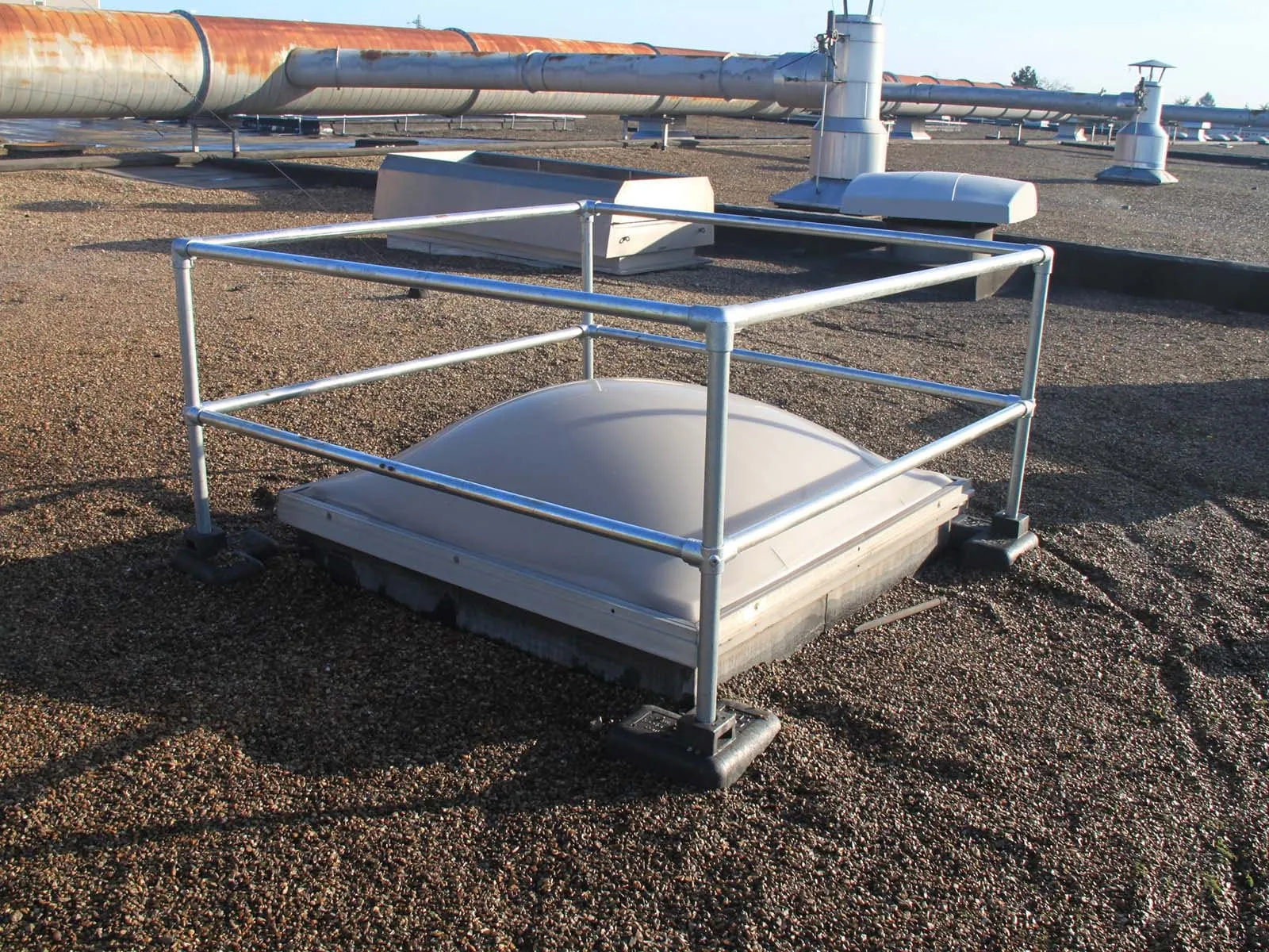 Freestanding skylight guardrail system installed on rooftop for fall hazard prevention