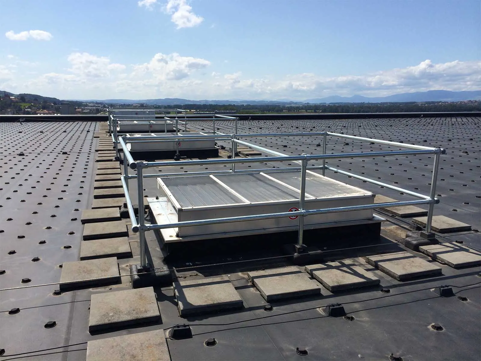 Freestanding skylight guardrail system installed on rooftop for fall hazard prevention