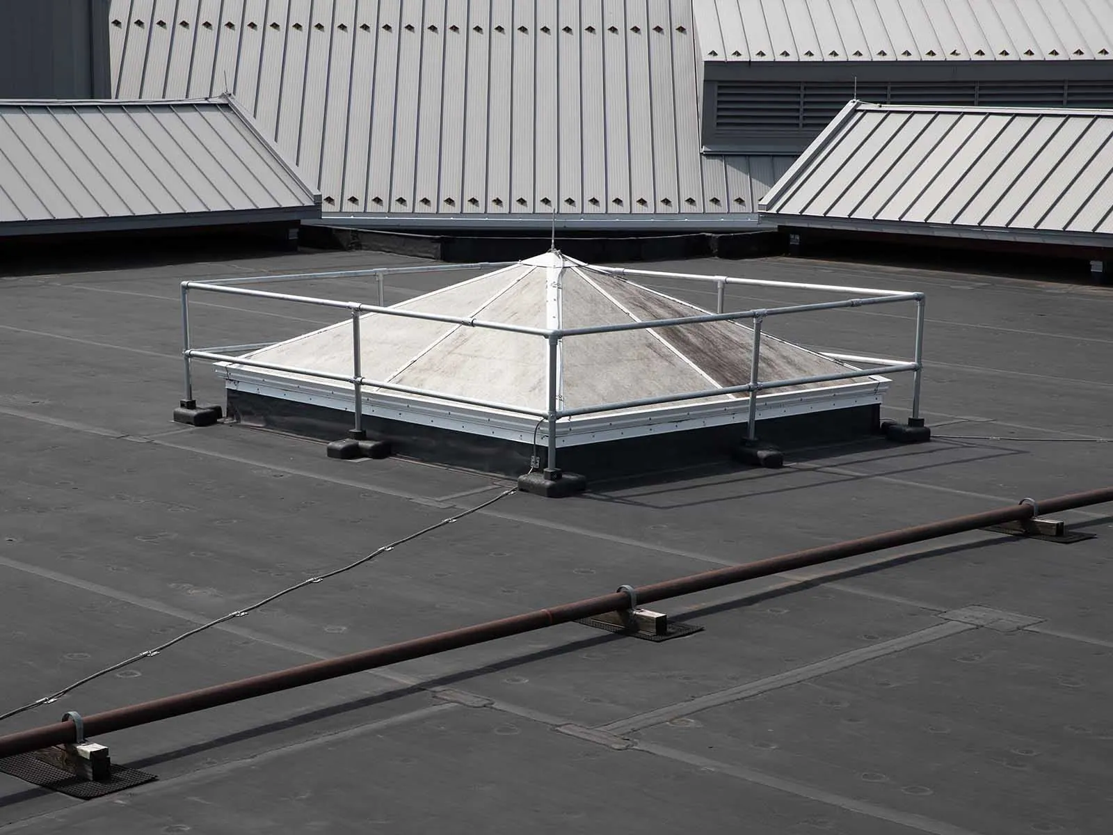 Freestanding skylight guardrail system installed on rooftop for fall hazard prevention
