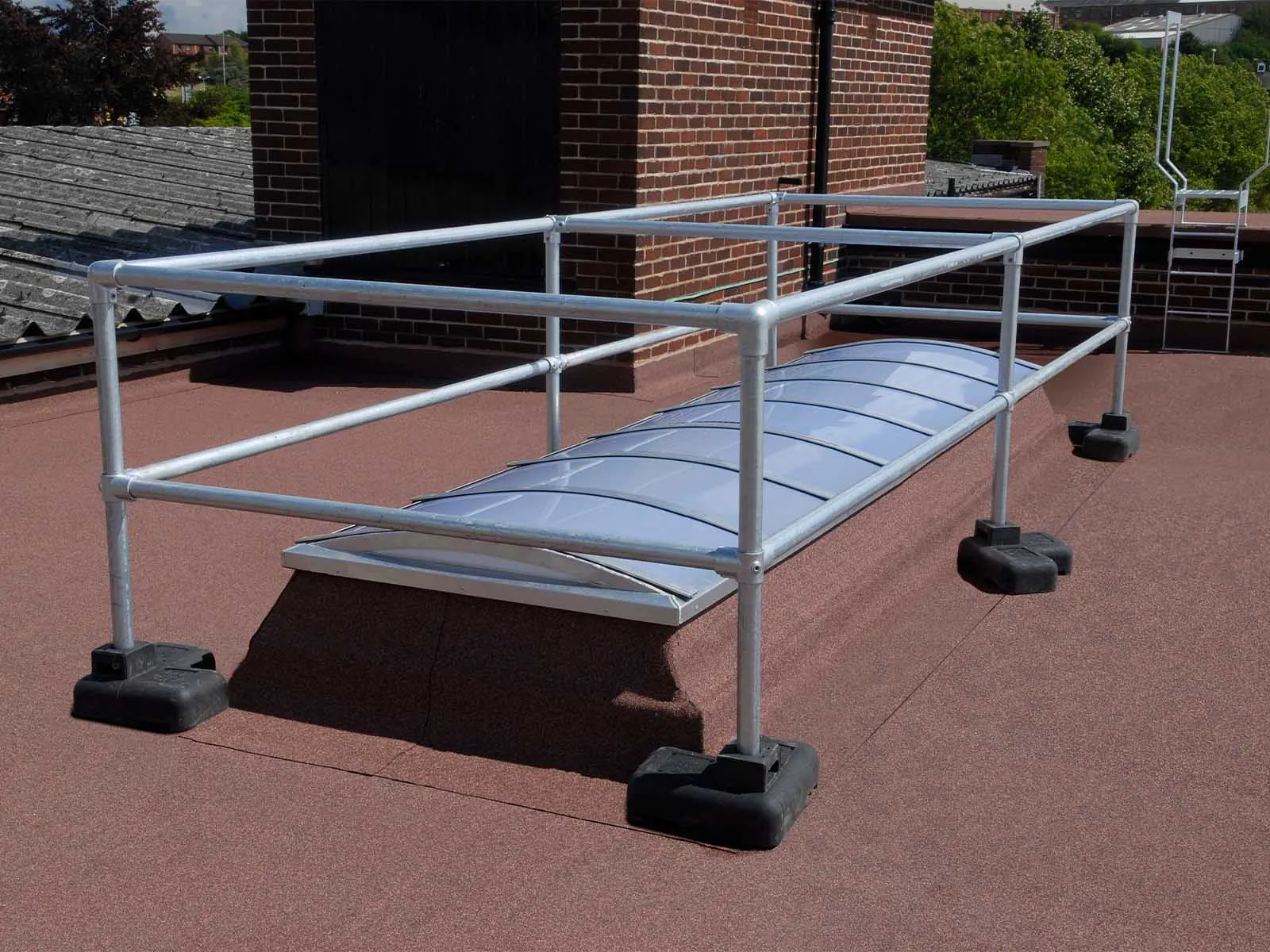 Freestanding skylight guardrail system installed on rooftop for fall hazard prevention