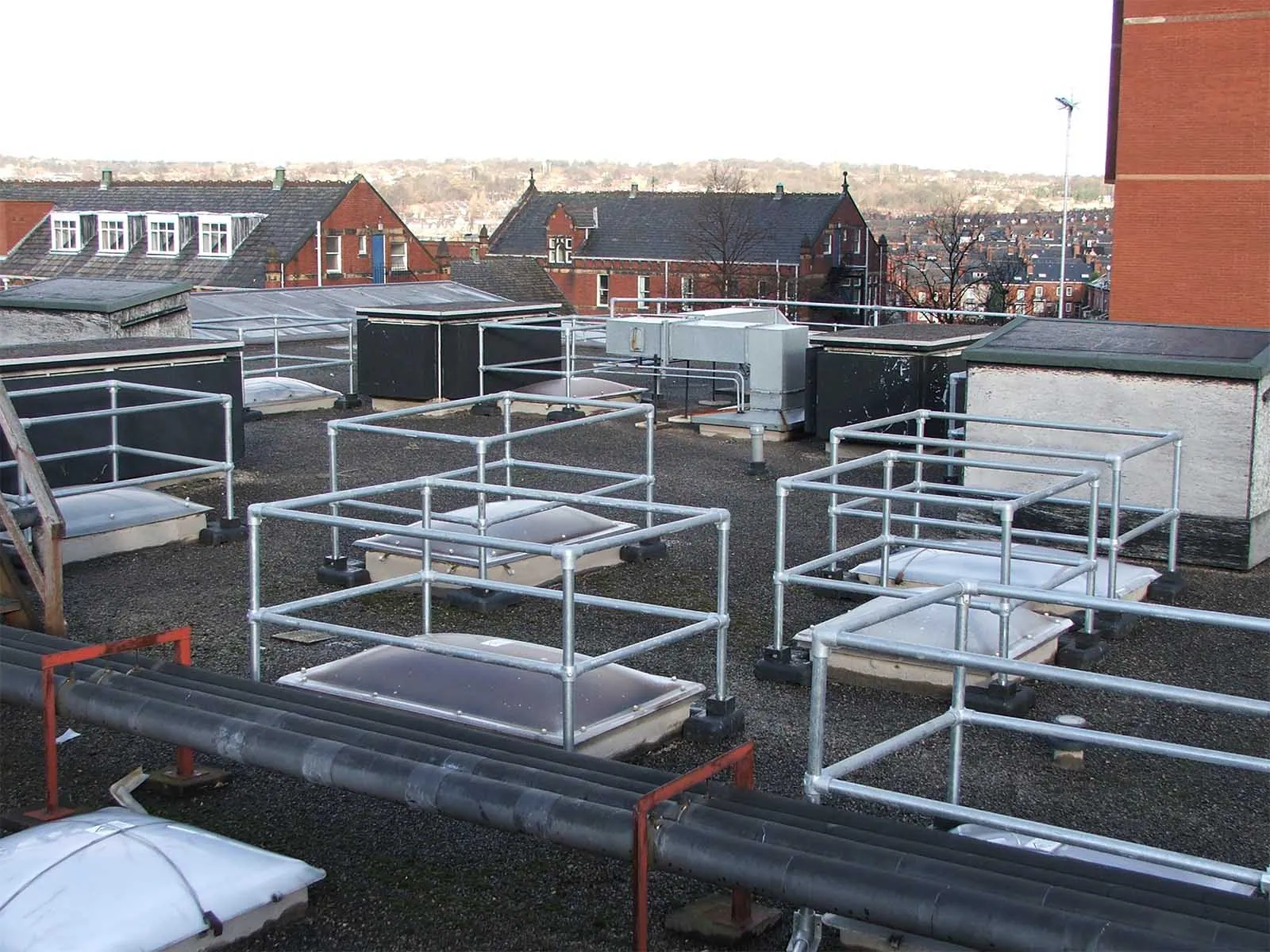 Freestanding skylight guardrail system installed on rooftop for fall hazard prevention