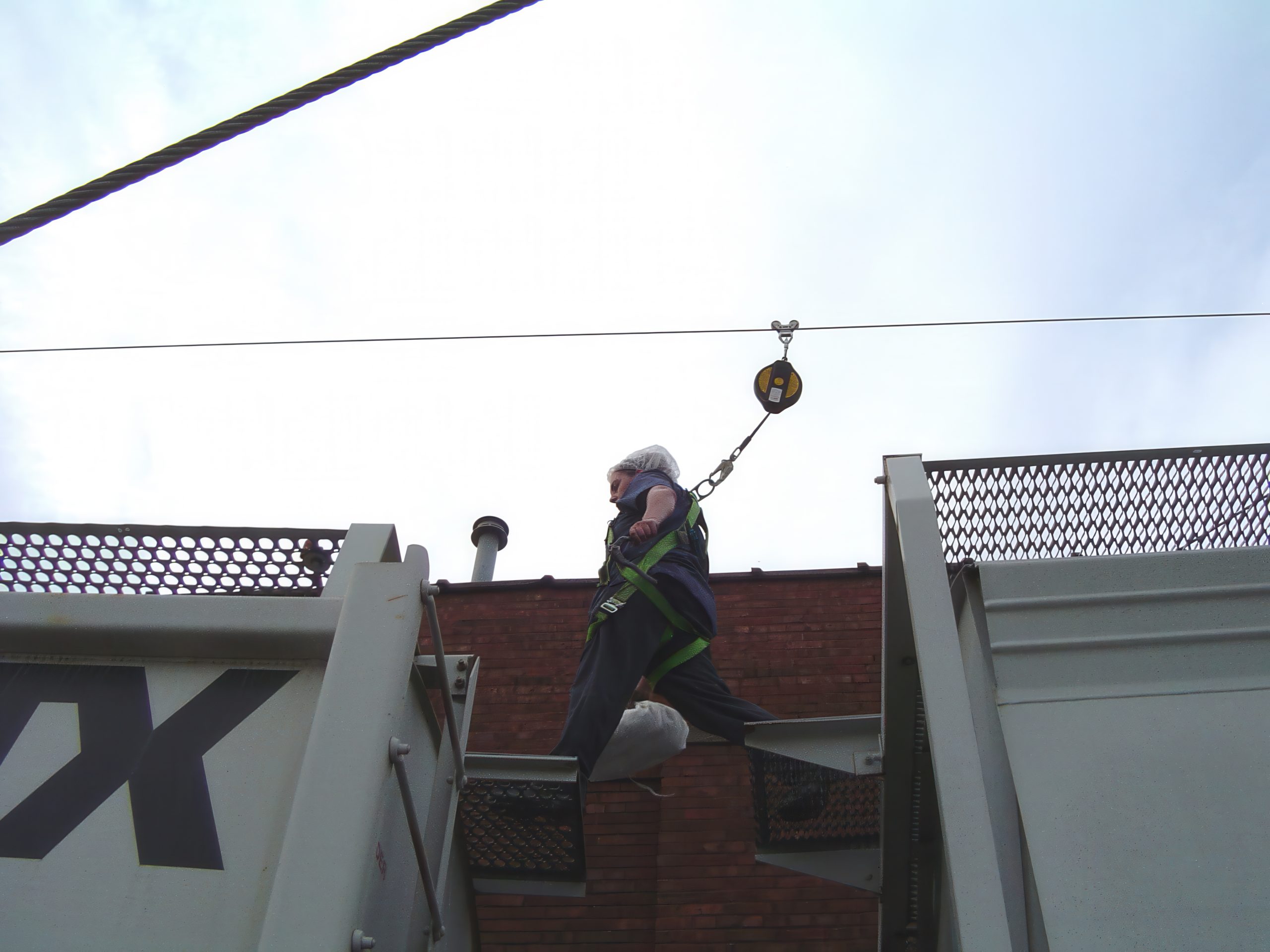 Worker utilizing personal fall arrest system on horizontal lifeline