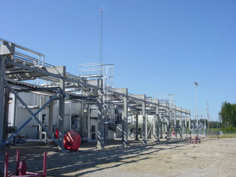 Row of galvanized access platforms and caged ladders over outdoor process equipment