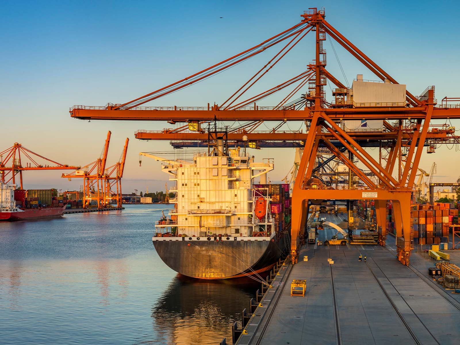 Dockworker secured with lifeline while performing tasks near vessel loading area